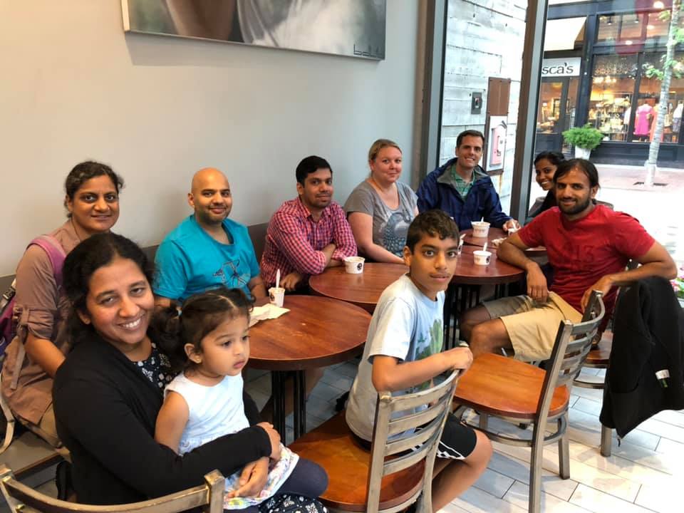 Large energetic team photo with hands raised